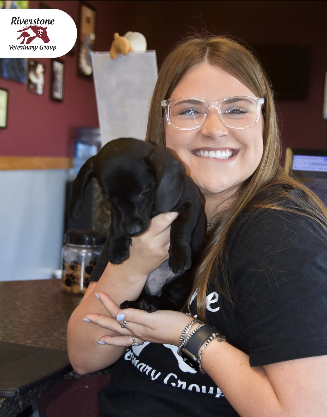 Team member with black puppy